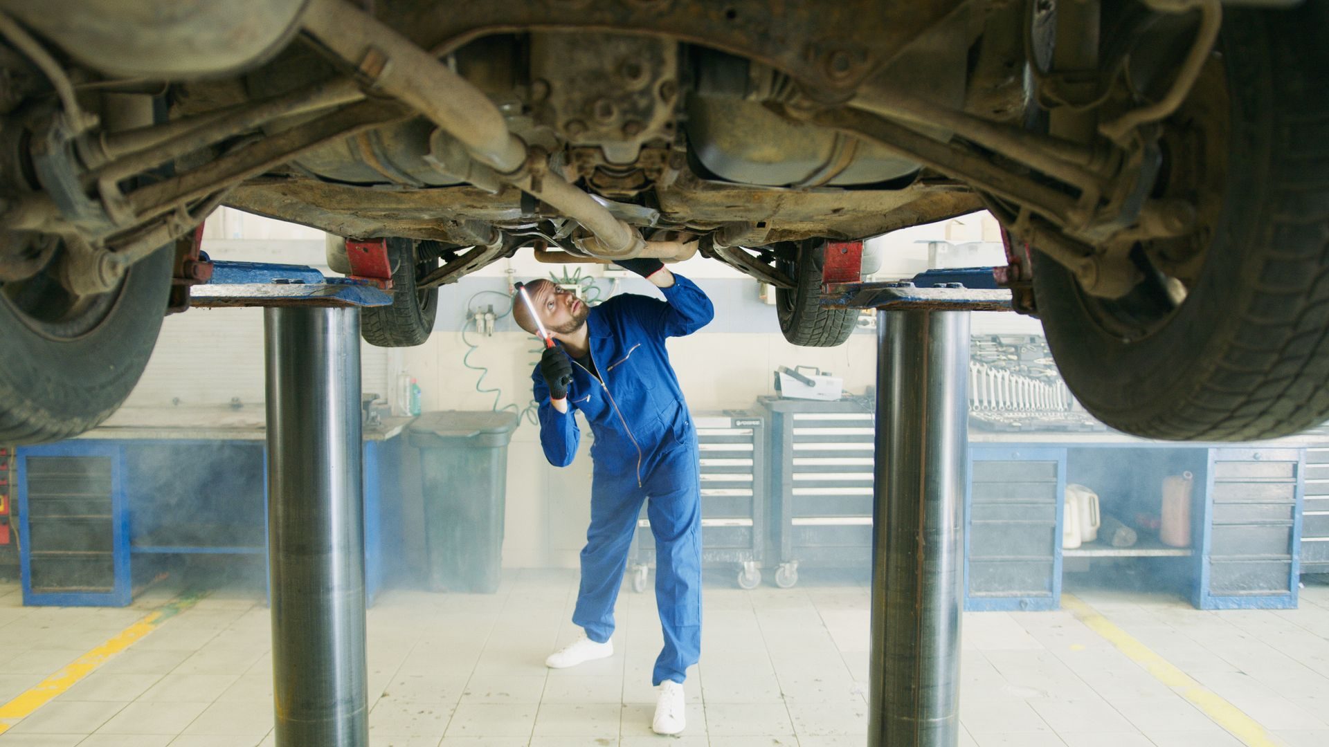 Mechaniker prüft ein Fahrzeug auf der Hebebühne